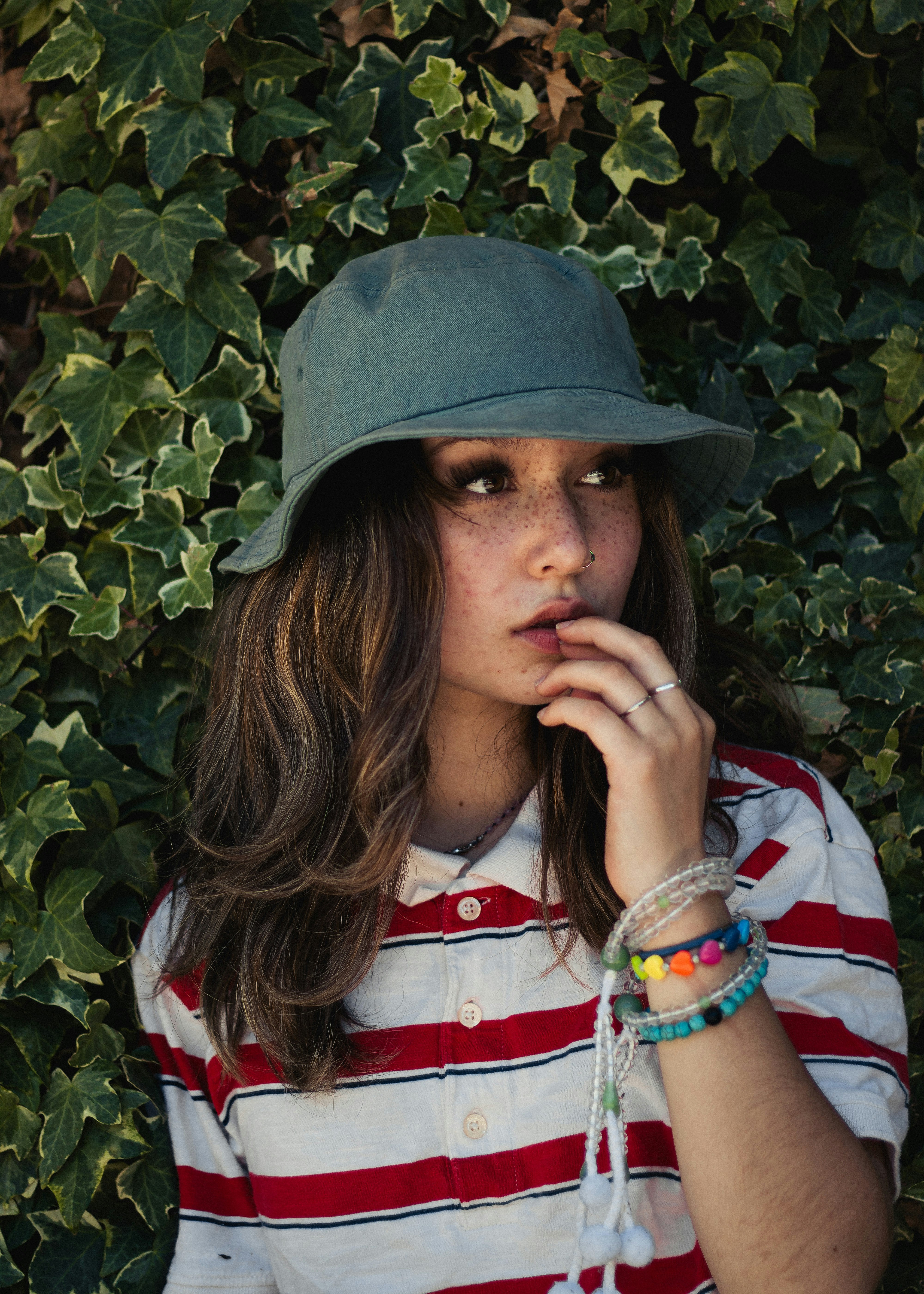 woman in white red and blue shirt wearing green hat