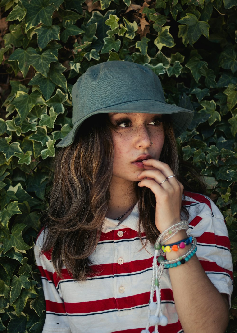 Mujer con camisa blanca, roja y azul con sombrero verde