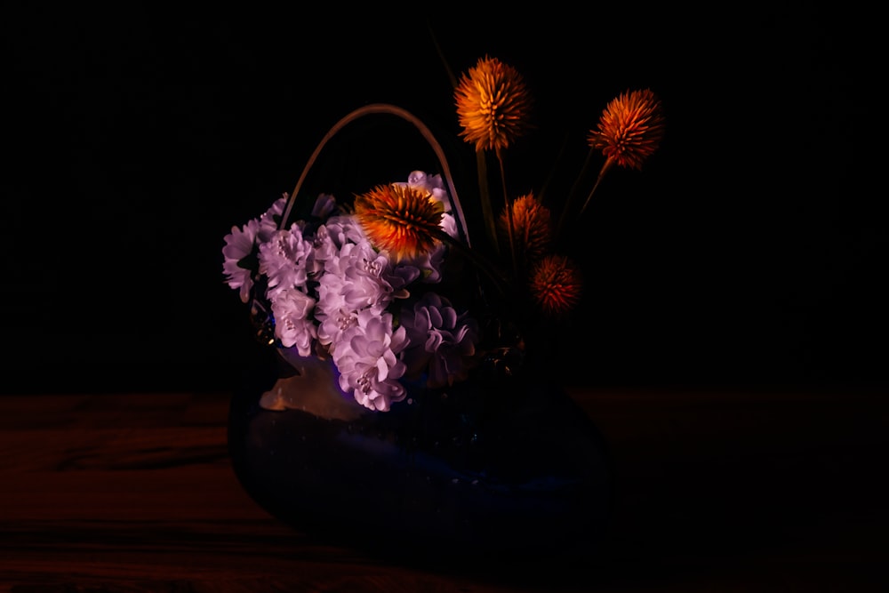 white and purple flowers in brown ceramic vase