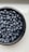 A close-up of fresh, organic blueberries in a wooden bowl.