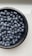 A close-up of fresh, organic blueberries in a wooden bowl.