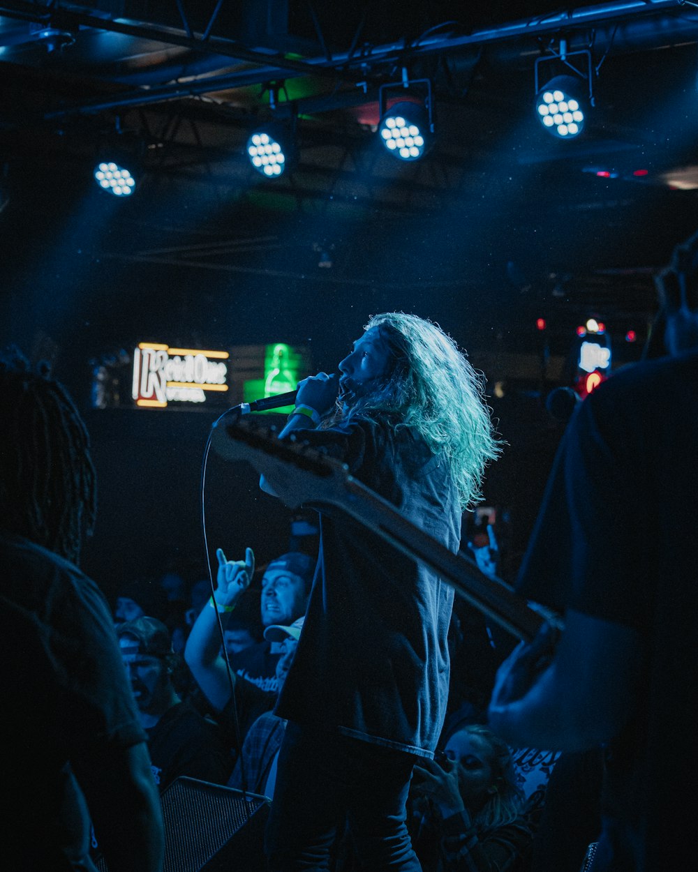 woman singing on stage during night time