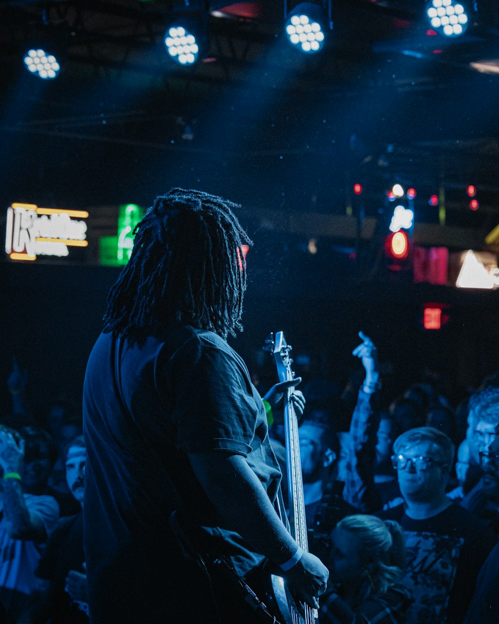 man singing on stage with people watching