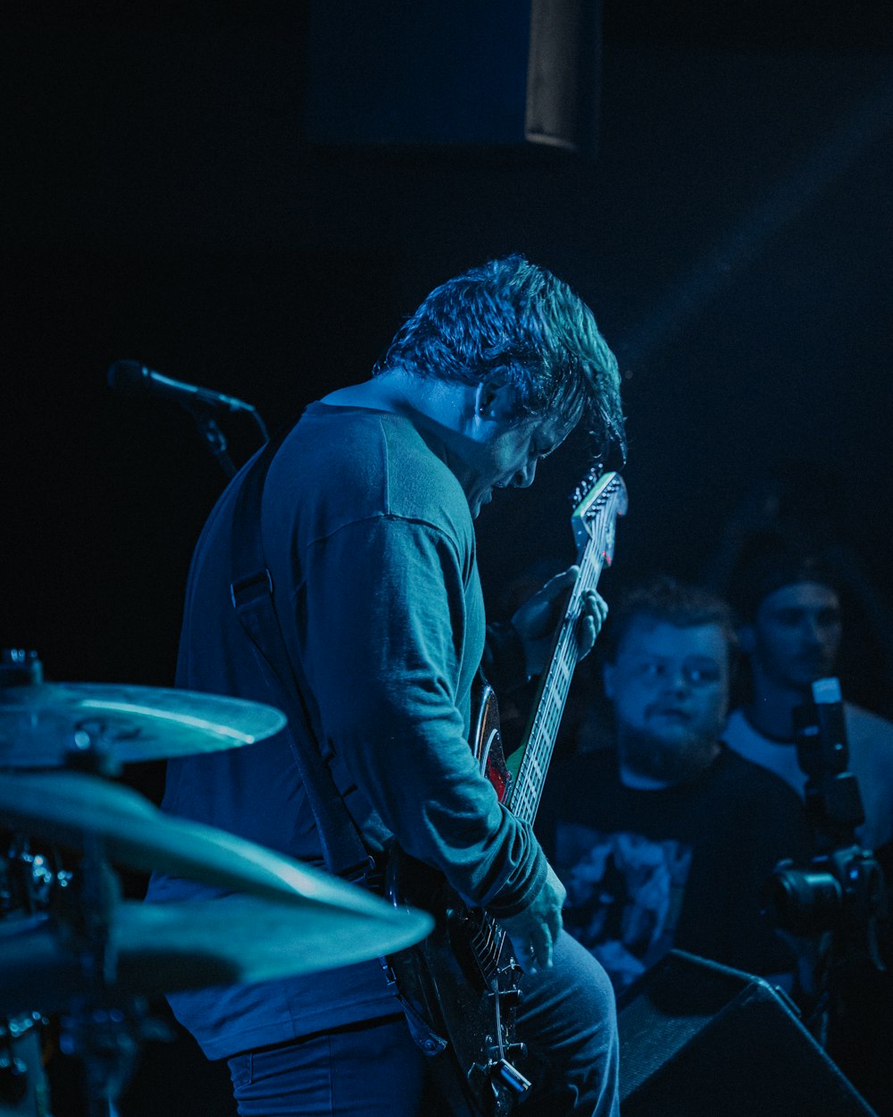 man in black shirt playing guitar