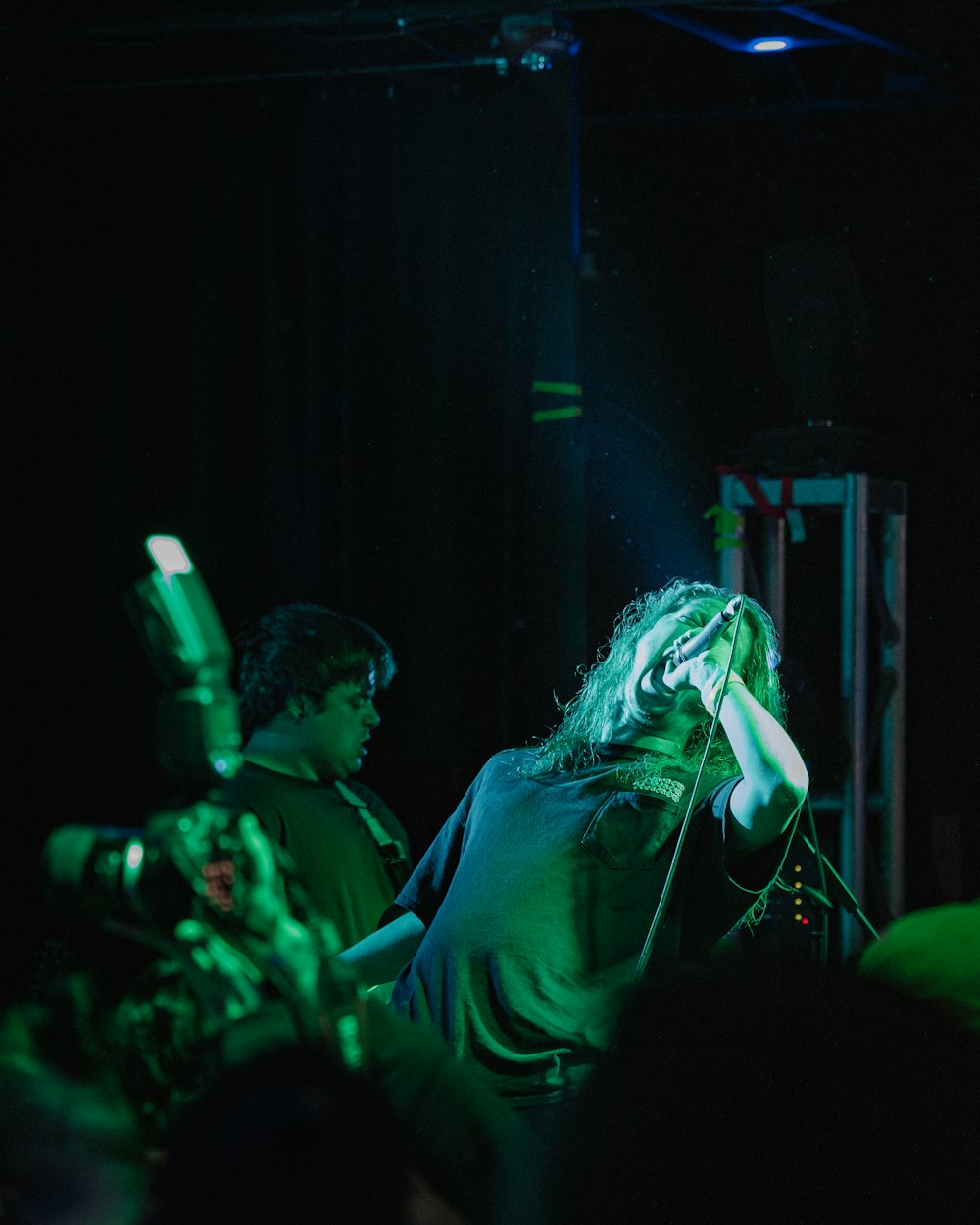 woman singing on stage in front of people