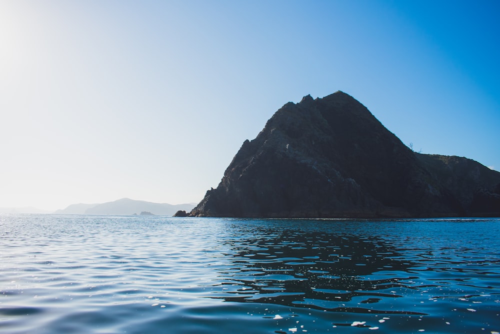 body of water near mountain during daytime