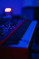 Red and black musical keyboard under a blue light