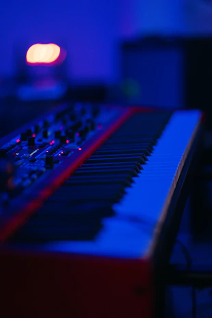 Red and black musical keyboard under a blue light