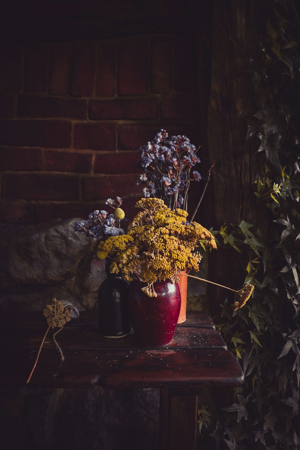 white and yellow flowers in red ceramic vase