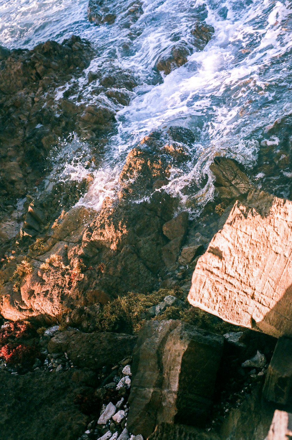 Formazione rocciosa marrone vicino allo specchio d'acqua durante il giorno