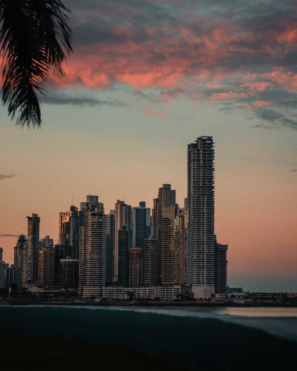 skyline della città attraverso lo specchio d'acqua durante il tramonto