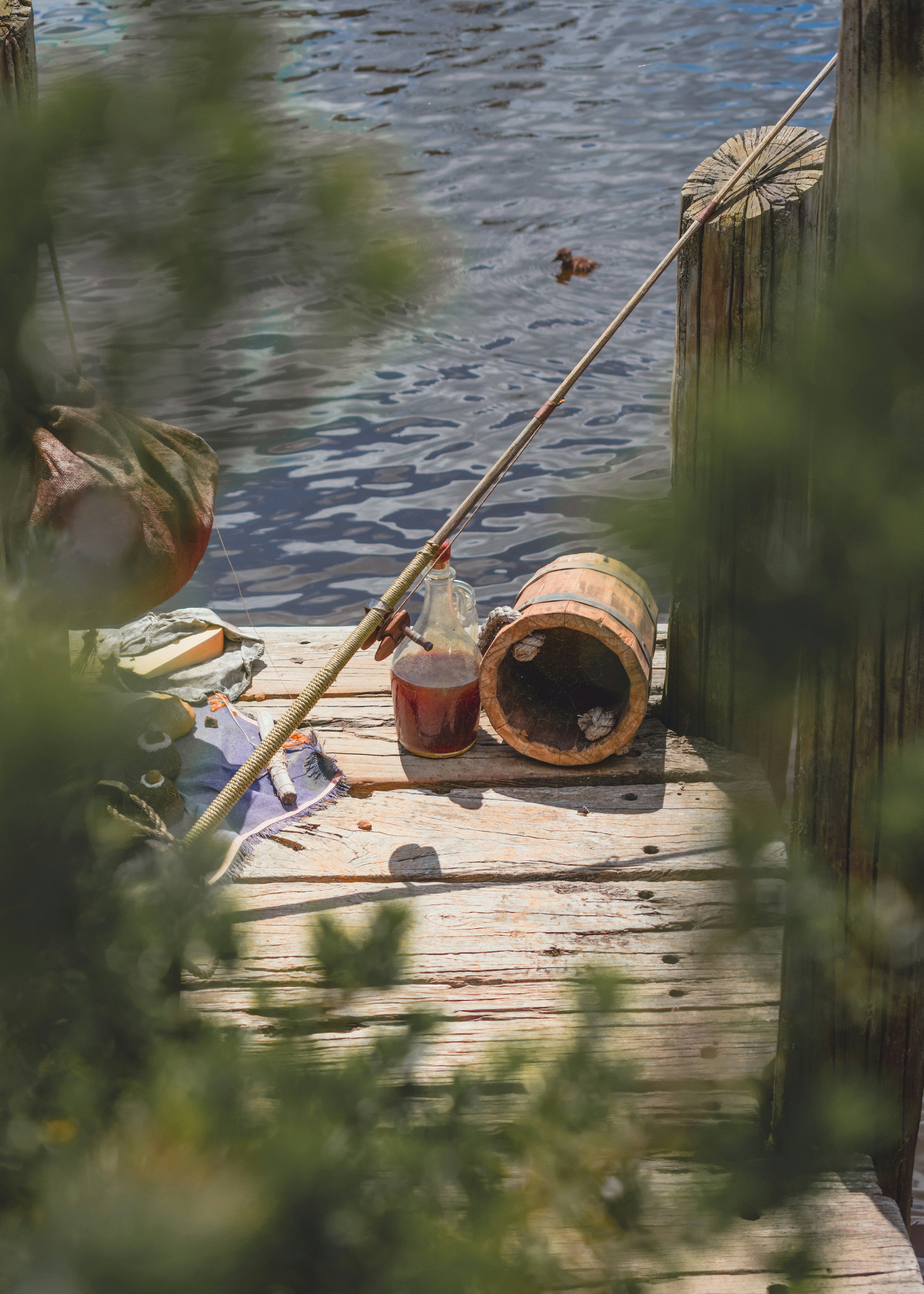 Canna da pesca in legno marrone su molo in legno marrone