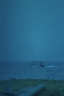 Lifestyle shot of a small boat powered by the U2 motor gliding silently over calm blue waters.