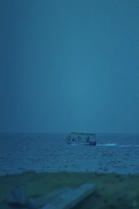Lifestyle shot of a small boat powered by the U2 motor gliding silently over calm blue waters.