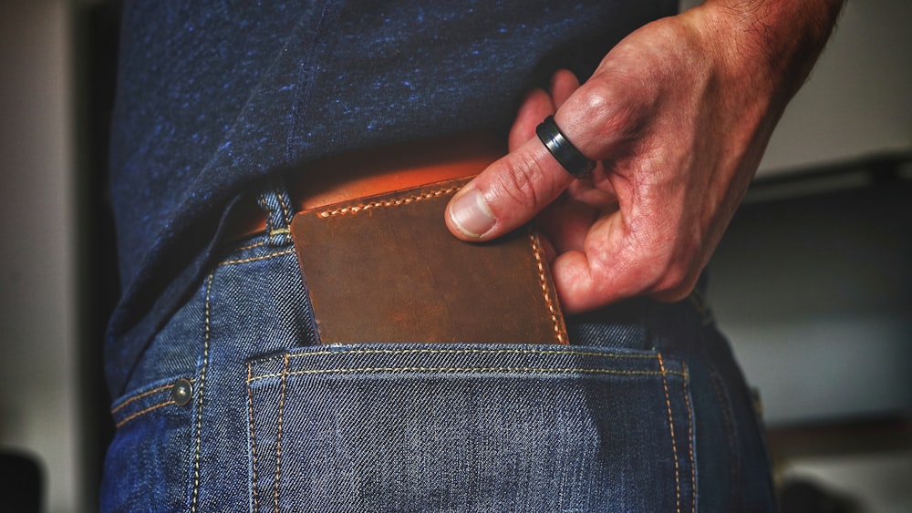 person holding black and brown leather bag