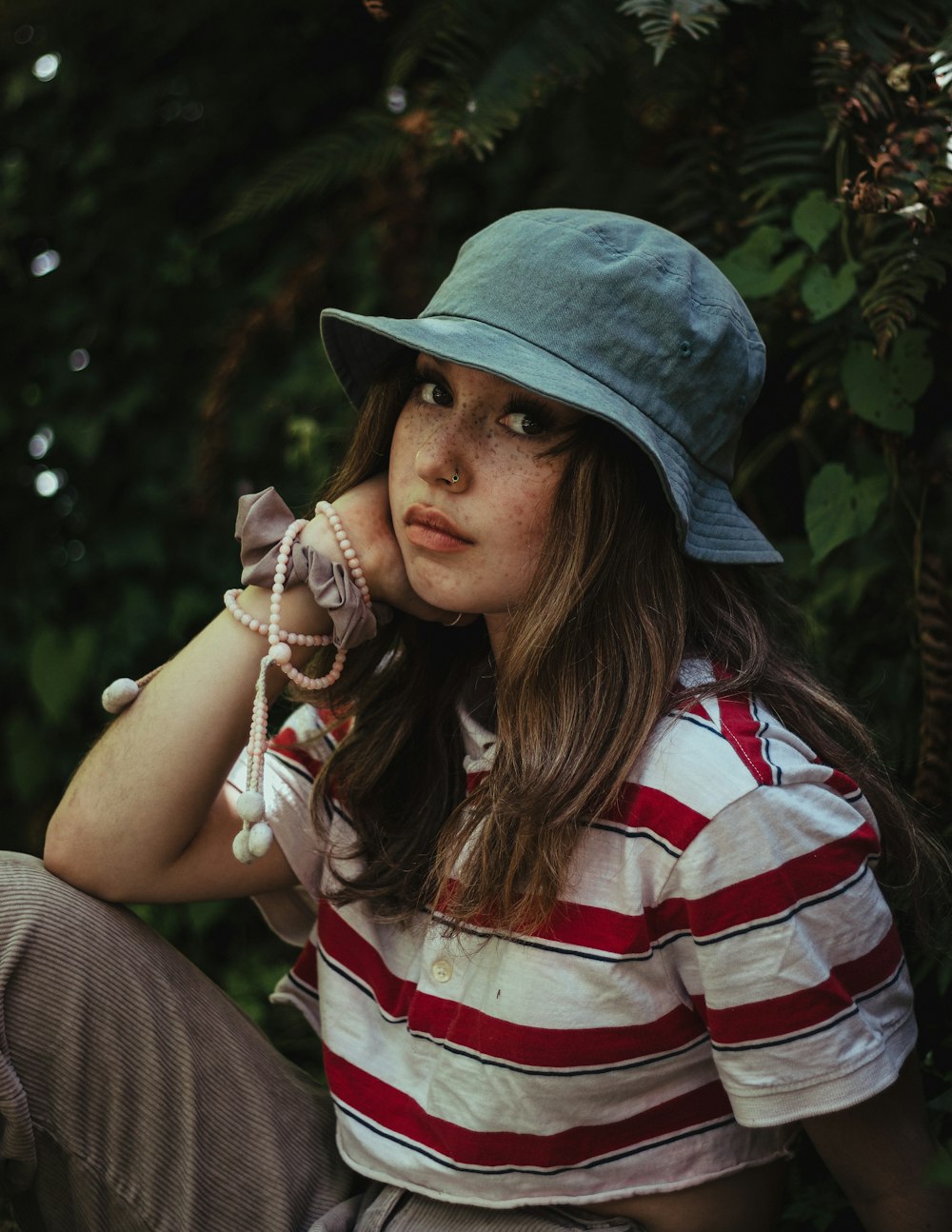 woman in white red and blue striped shirt wearing blue hat