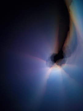 Abstract representation of faith and technology merging, with light beams over dark background.