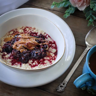 A peaceful morning setup with a nourishing oatmeal bowl topped with fresh berries and nuts by a sunlit window.