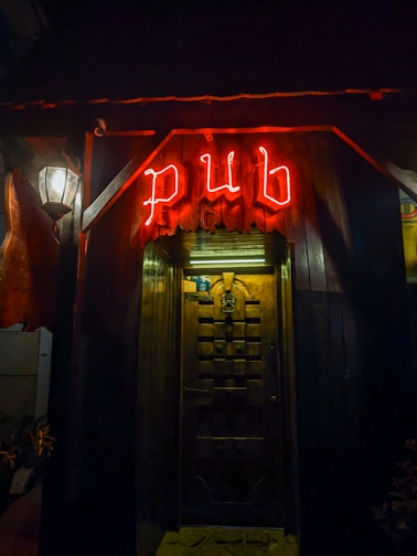 a red neon sign that reads pub above a doorway