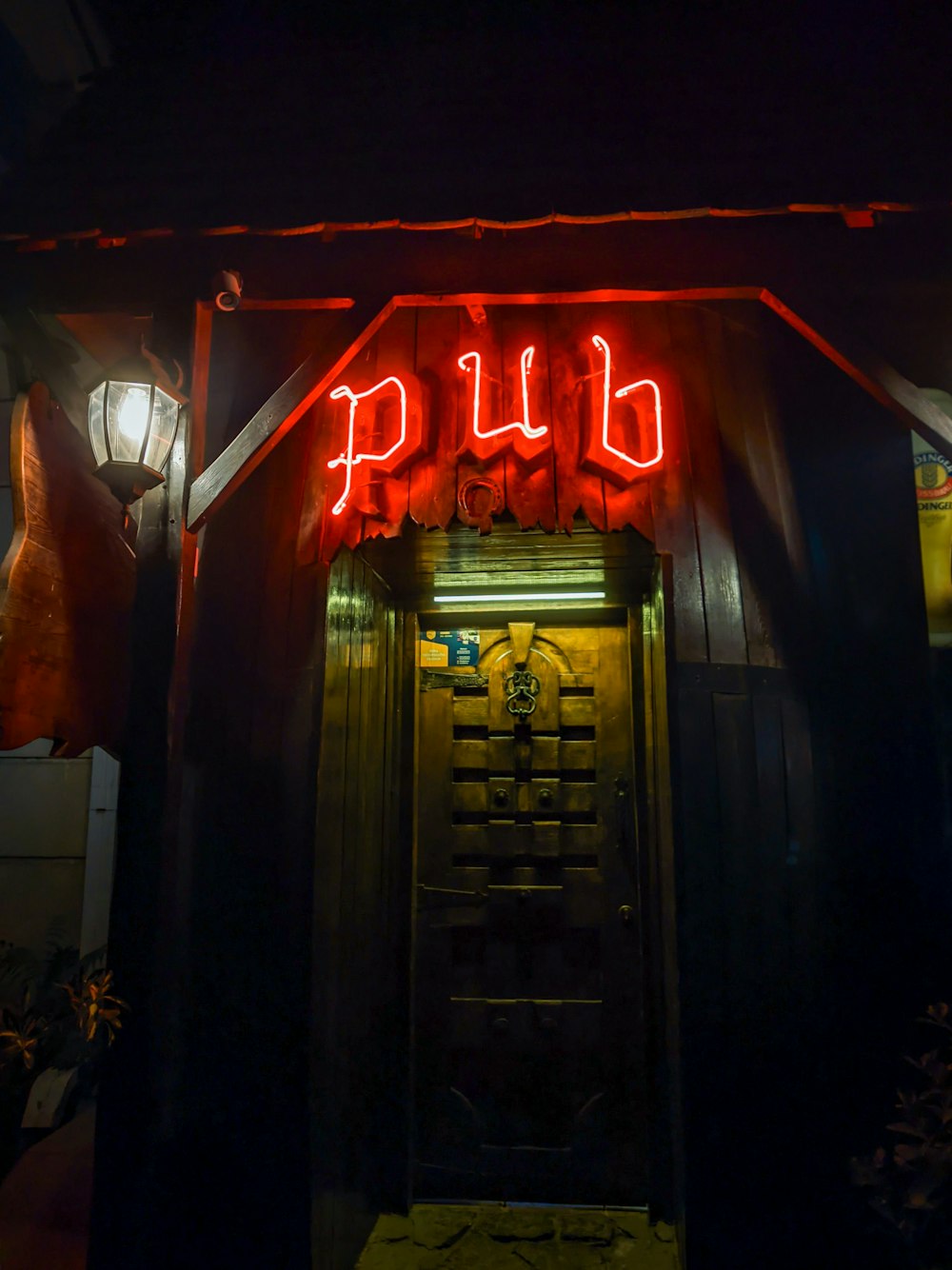Un letrero de neón rojo que dice pub sobre una puerta