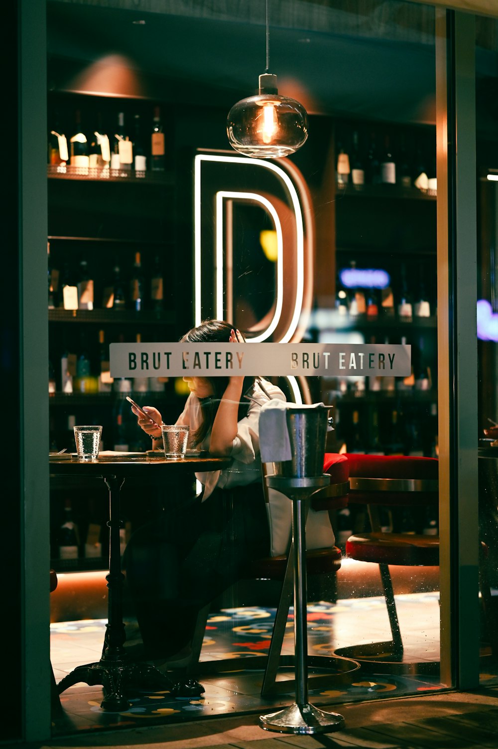 man in black t-shirt standing near glass door