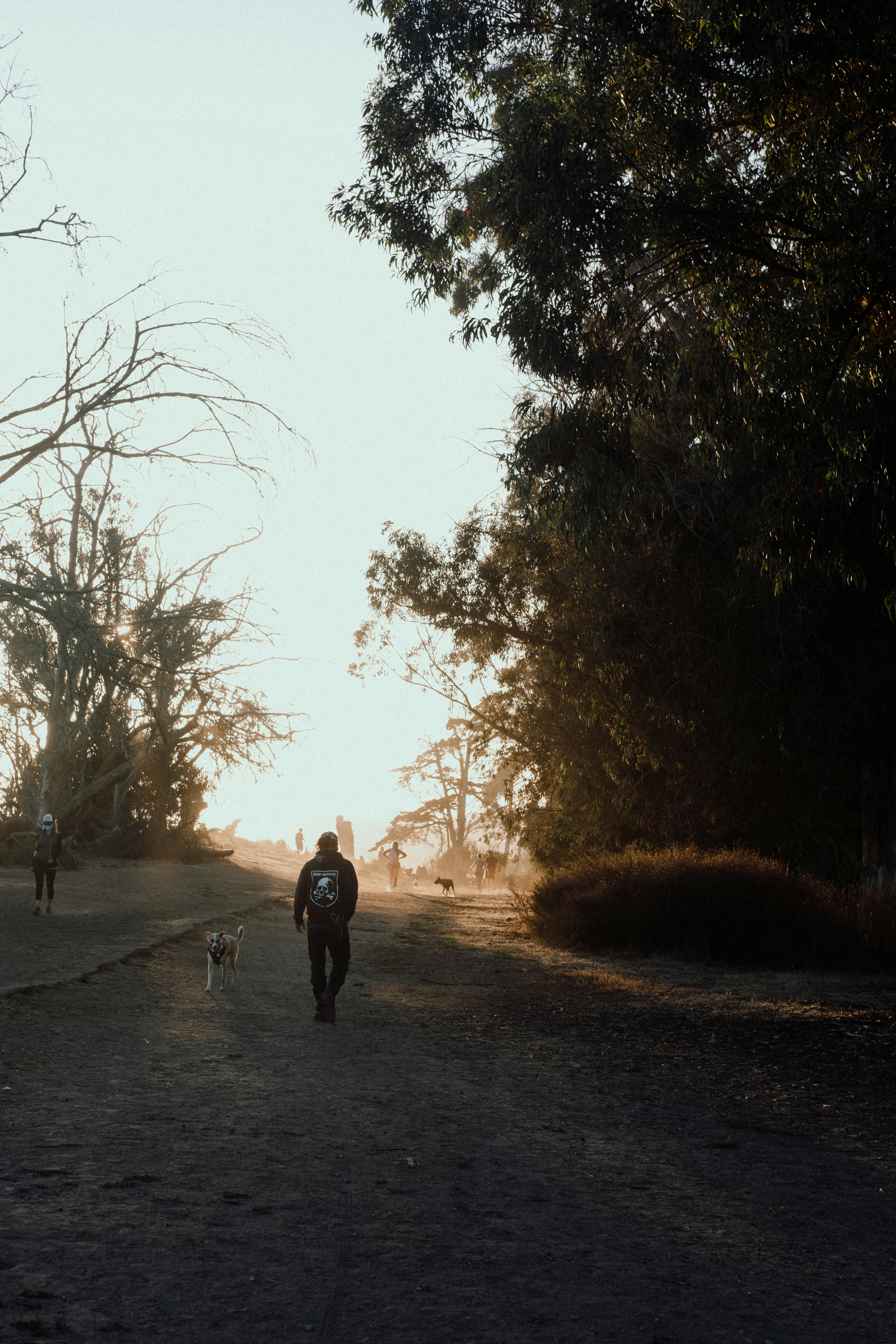 man in black jacket walking on road during daytime