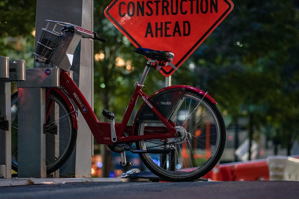 Bicicleta roja con letrero rojo y blanco de no fumar