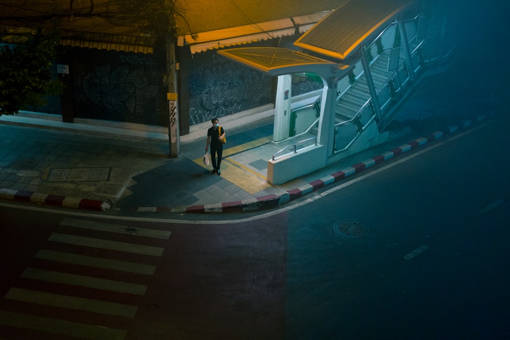 man in black jacket walking on sidewalk during daytime