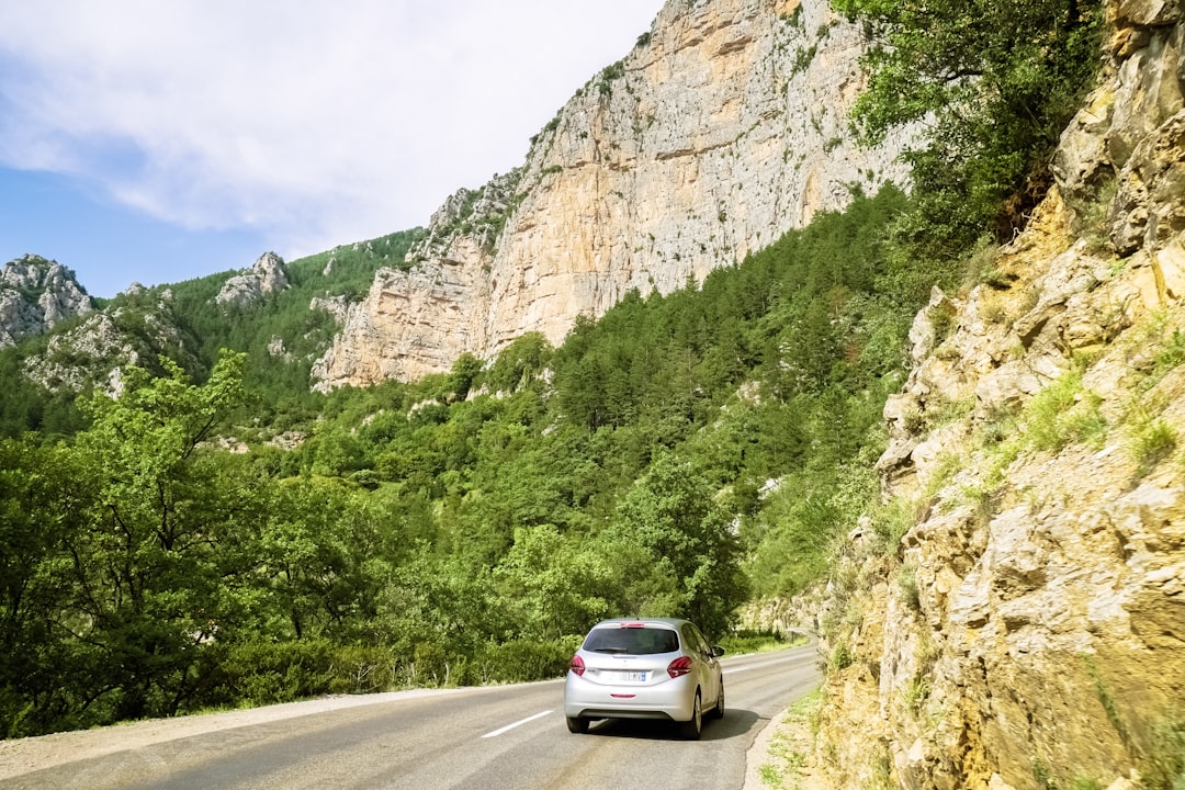 white car on road near mountain during daytime