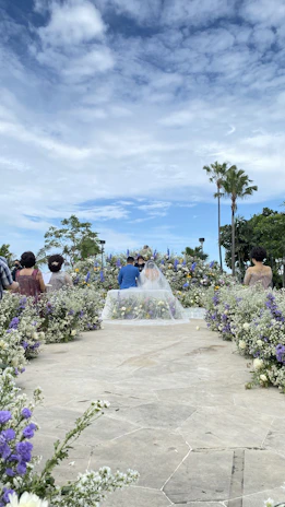 A beautifully decorated outdoor wedding altar with floral arrangements and soft lighting at sunset.