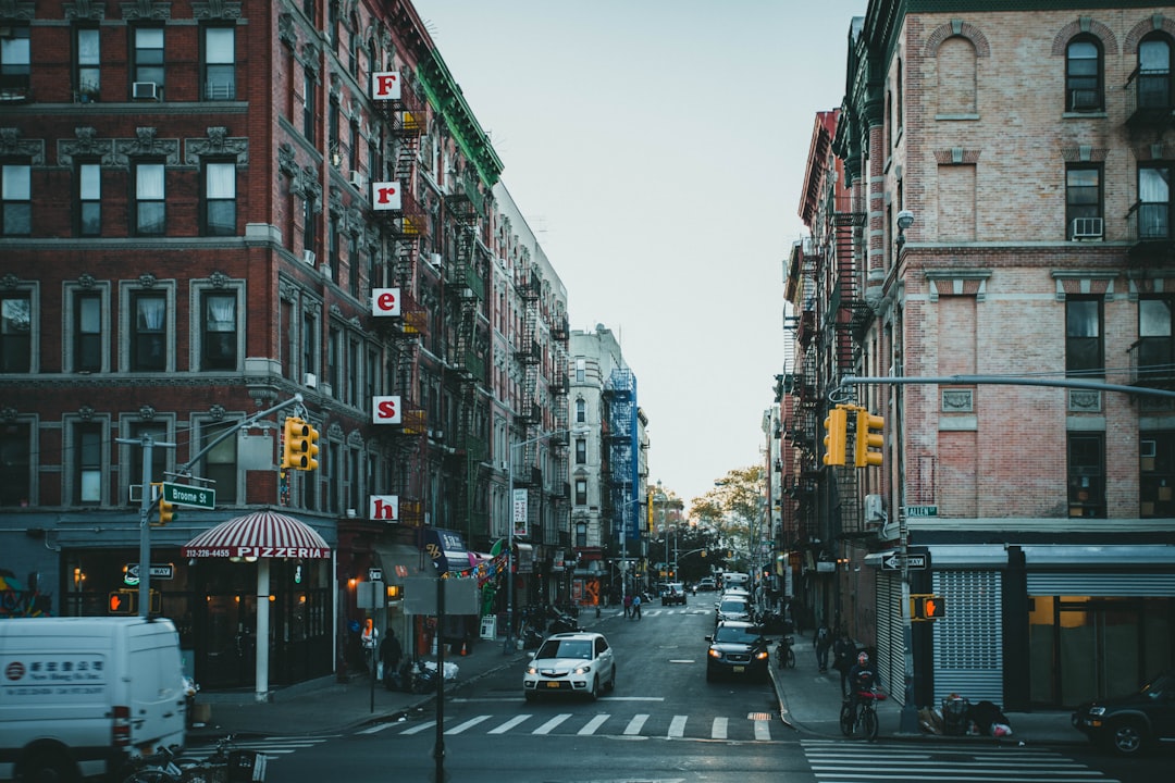 cars parked on side of the road in between buildings during daytime