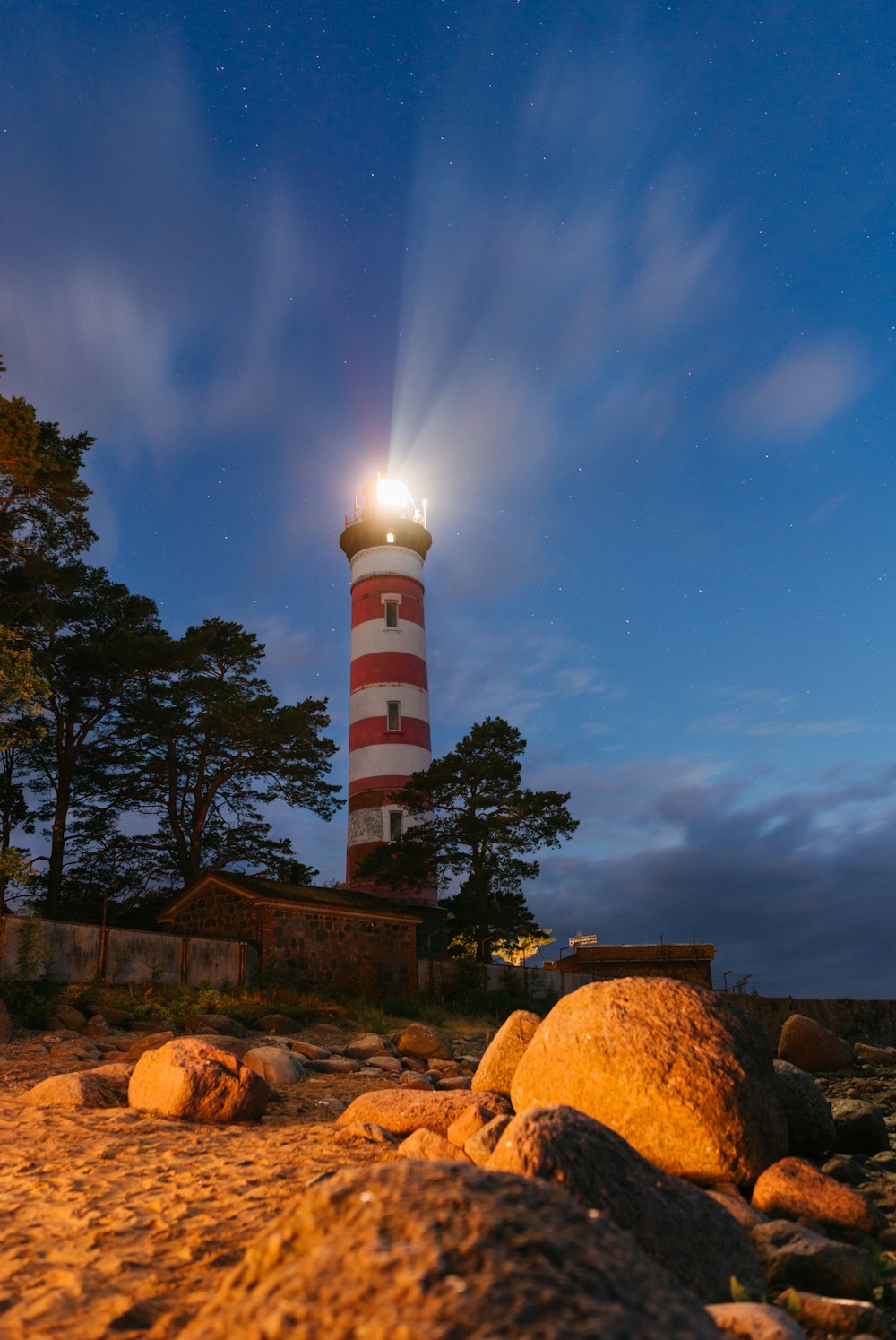 white and red striped lighthouse under blue sky during daytime