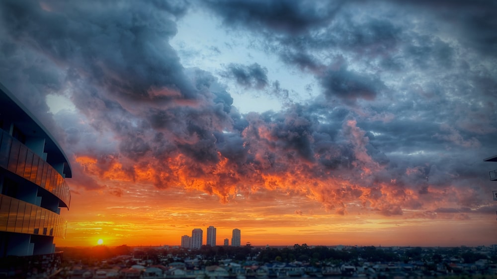 city skyline under gray clouds during sunset