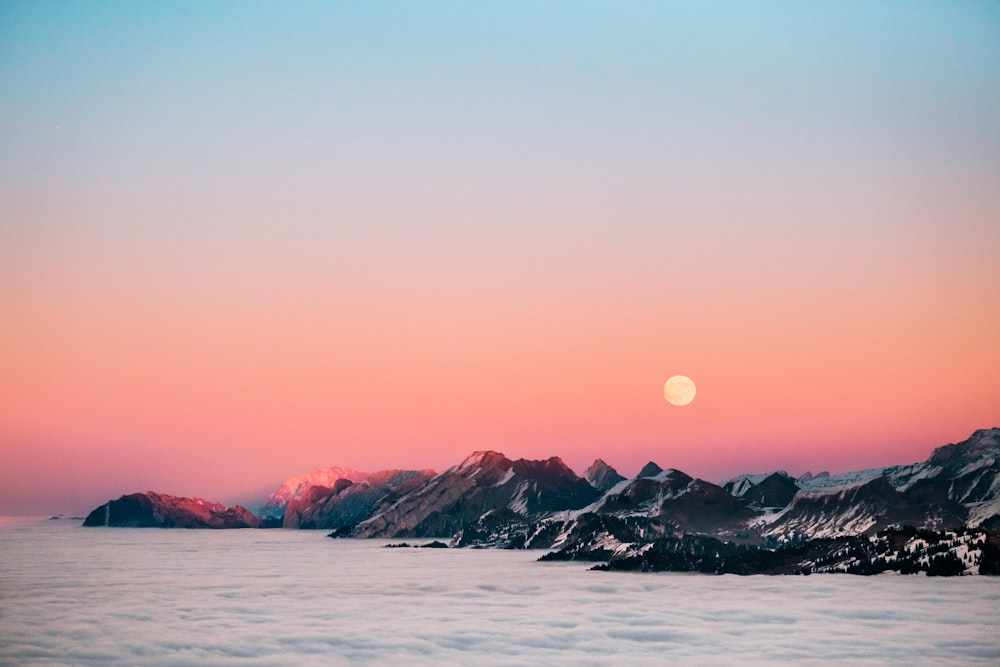 snow covered mountain near body of water during daytime