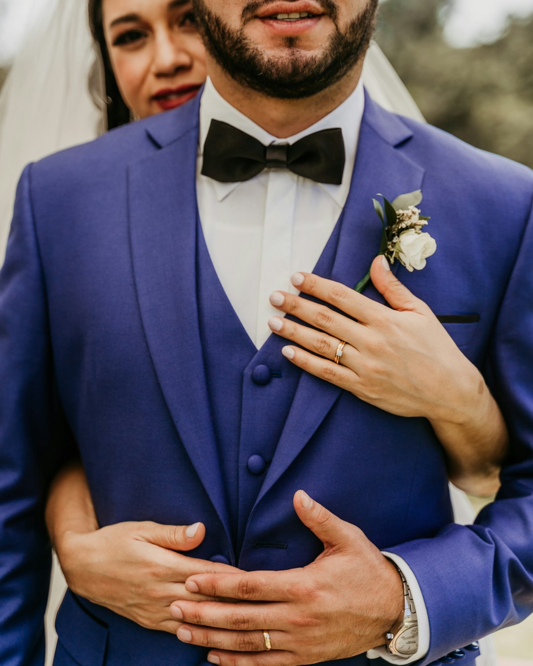 man in blue suit jacket holding white rose