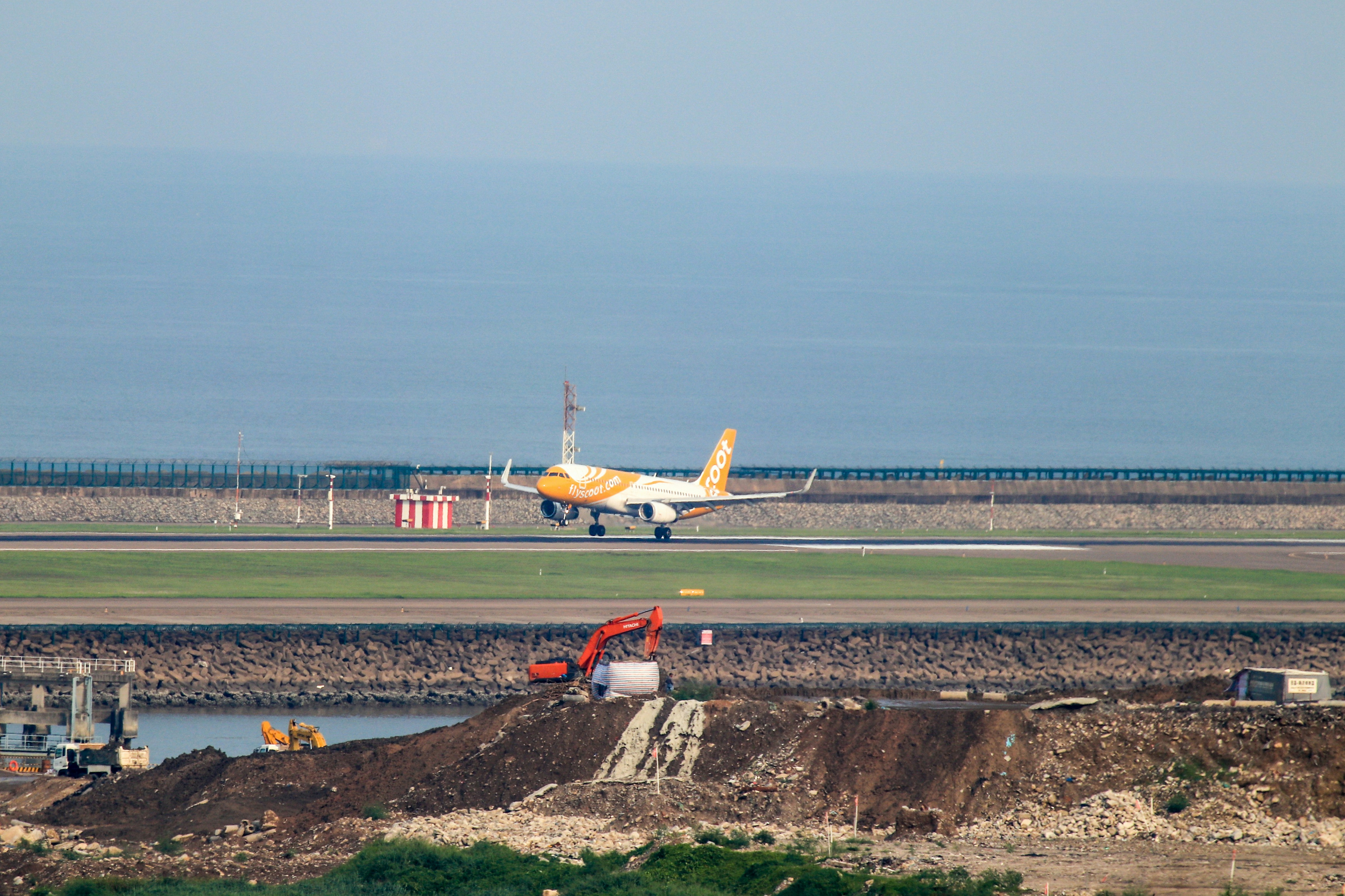 white and orange airplane on airport during daytime, Scoot TR904 Singapore - Macau, landing at the Macau International Airport, Macau, China