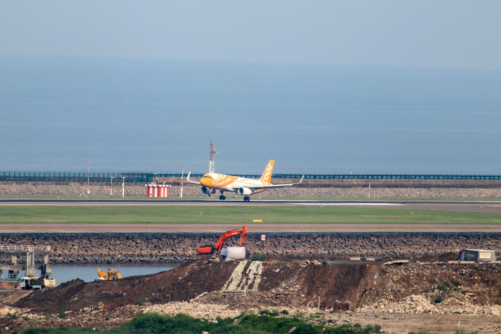 white and orange airplane on airport during daytime