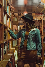 A woman browsing through a collection of books in a quaint bookstore.