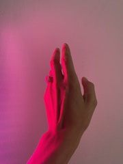 persons hand on pink textile
