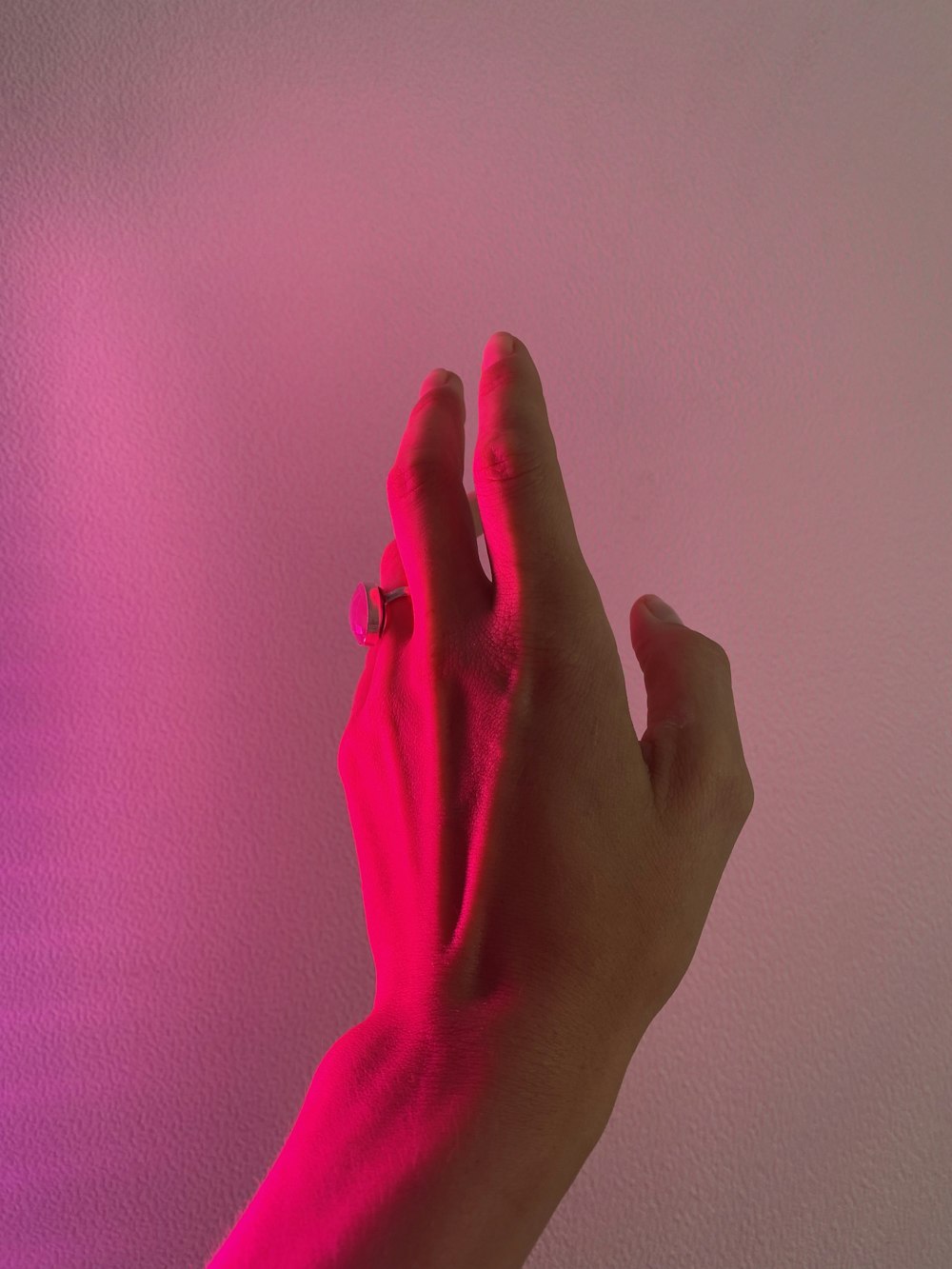 persons hand on pink textile