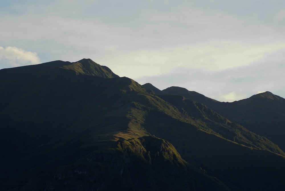 brown and green mountain under white clouds during daytime