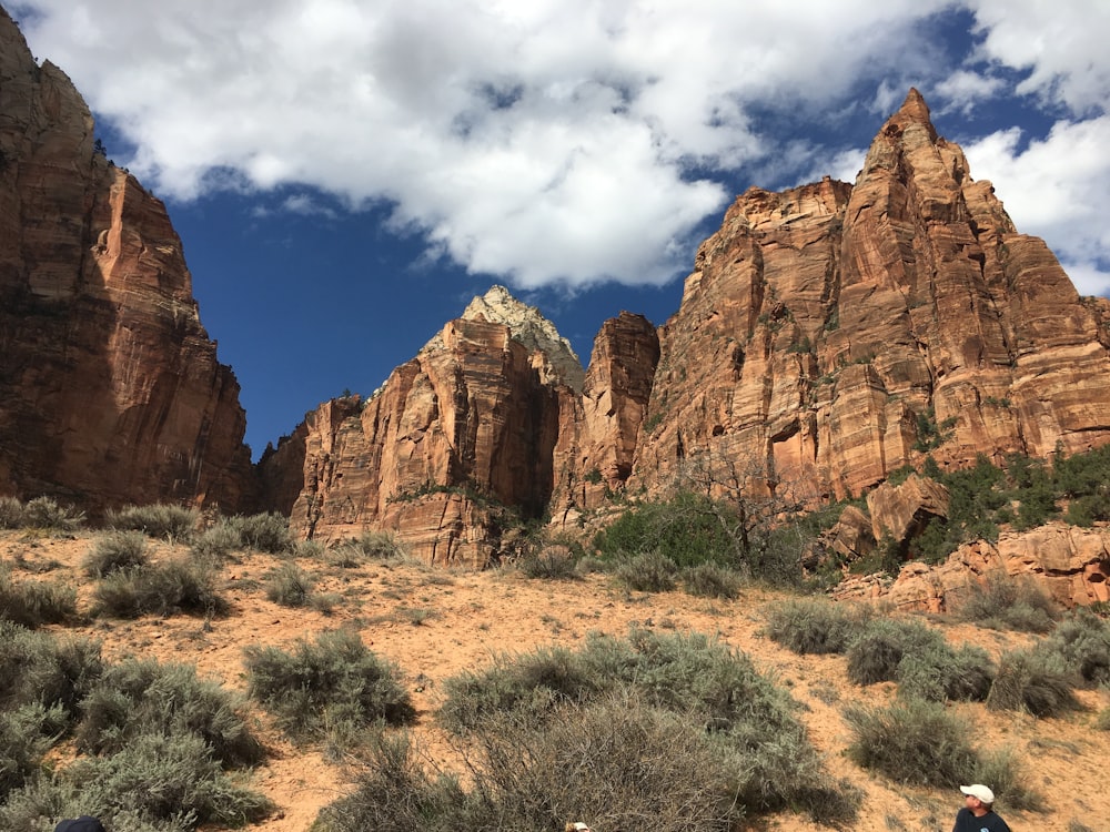 brown rock formation under white clouds and blue sky during daytime