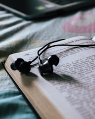 black earbuds on white book page