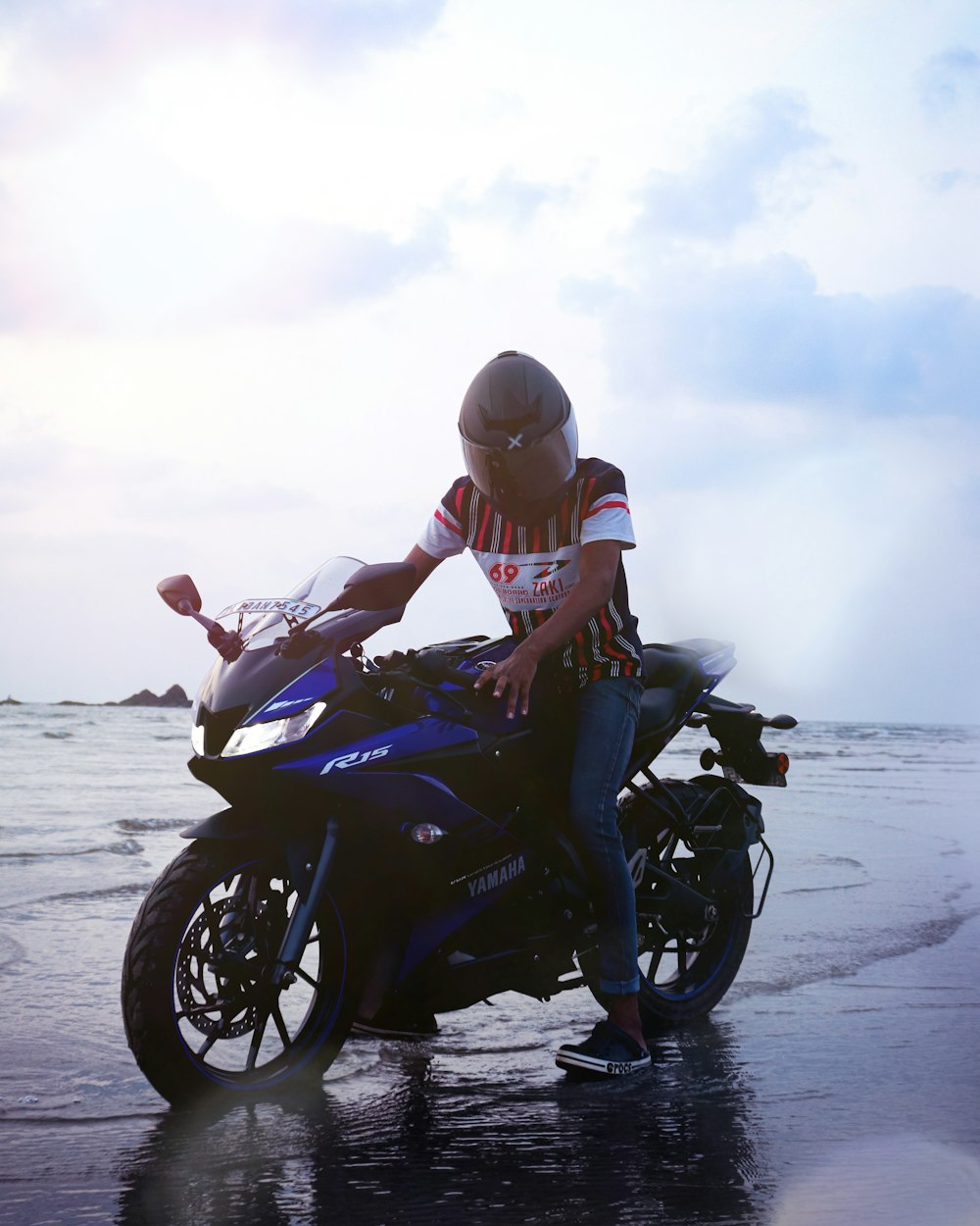 woman in black sports bike on beach during daytime