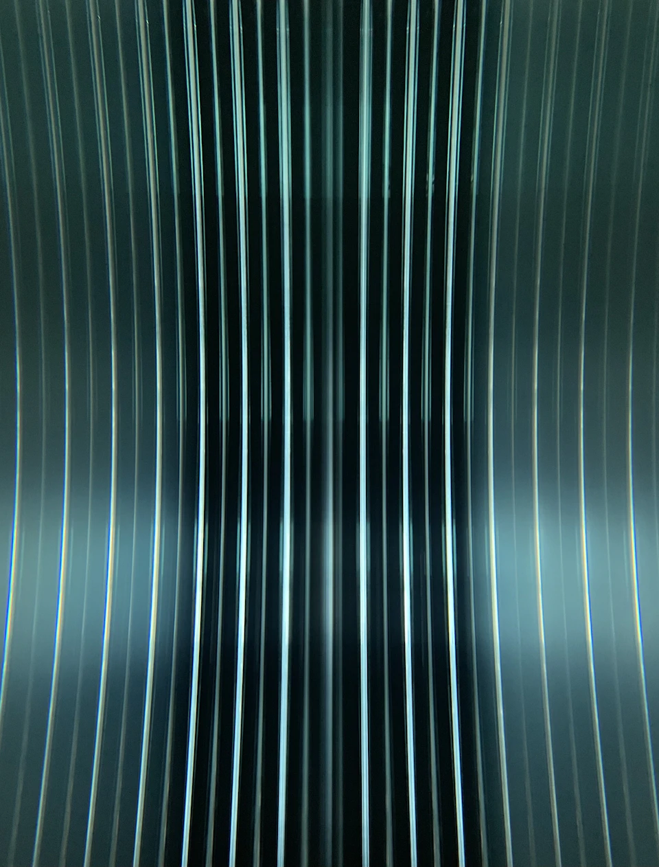 Close-up view of a metallic surface with numerous vertical lines in zigzag formation