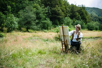 man in white shirt sitting on brown wooden chair