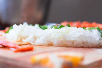 Close-up of premium dehydrated onion flakes neatly arranged on a rustic wooden surface.
