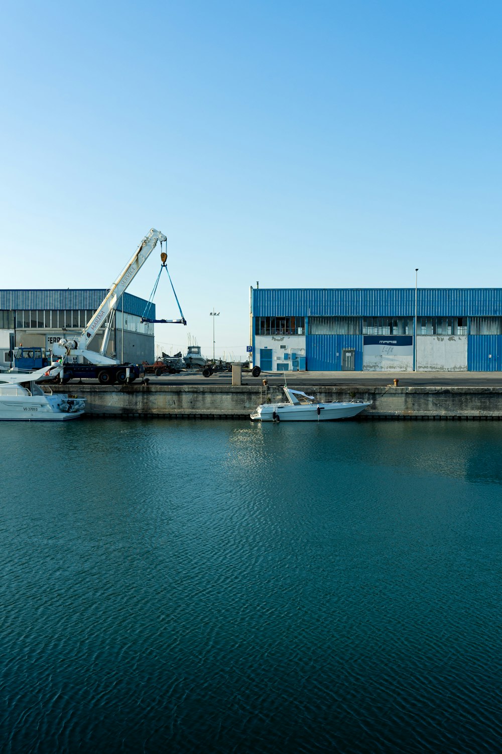 white and blue boat on dock during daytime