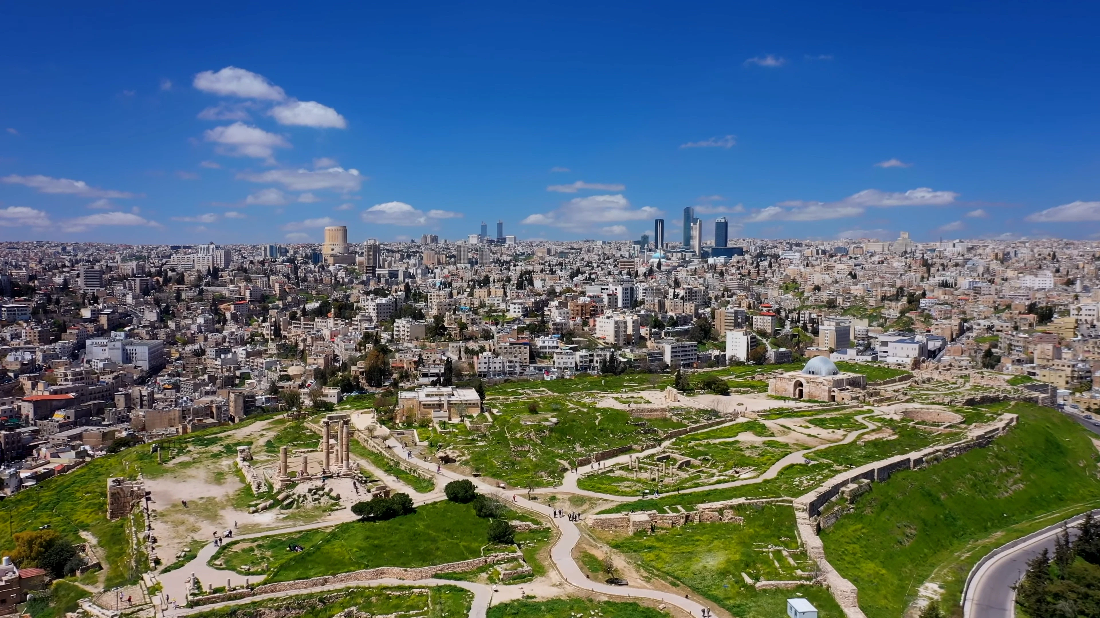 Aerial view over the ruins of the Amman Citadel hill with the pale-stone city and modern skyline beyond, Amman, Jordan