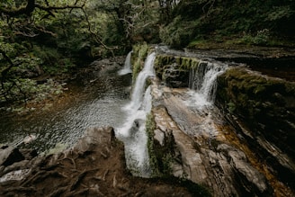water falls on brown rocky mountain